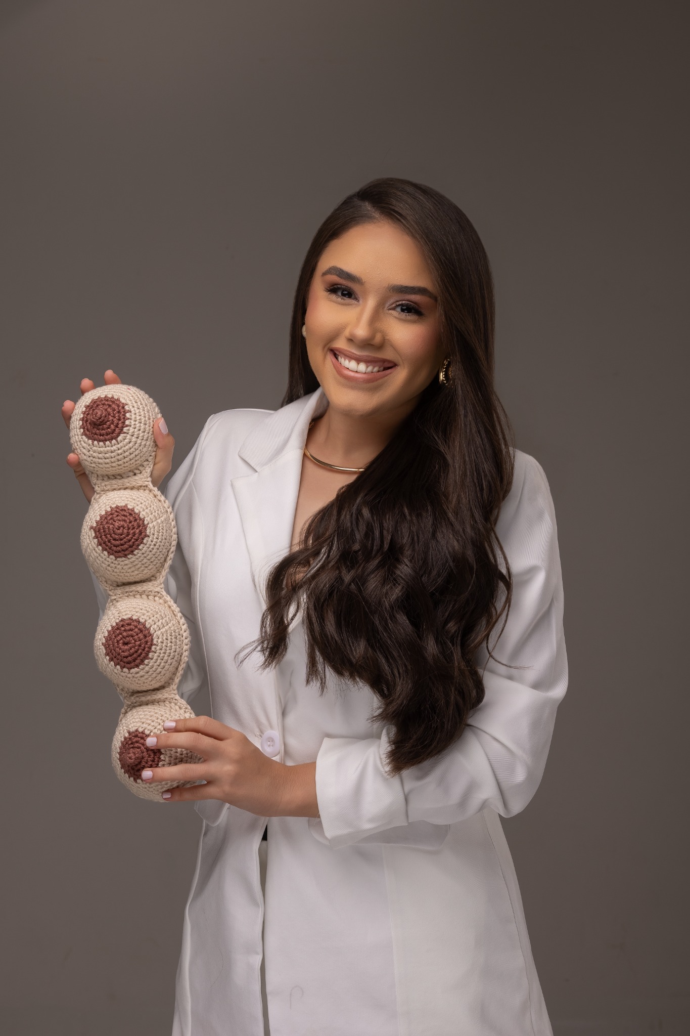 Bianca Almeida segurando modelos didáticos usados nas orientações de amamentação